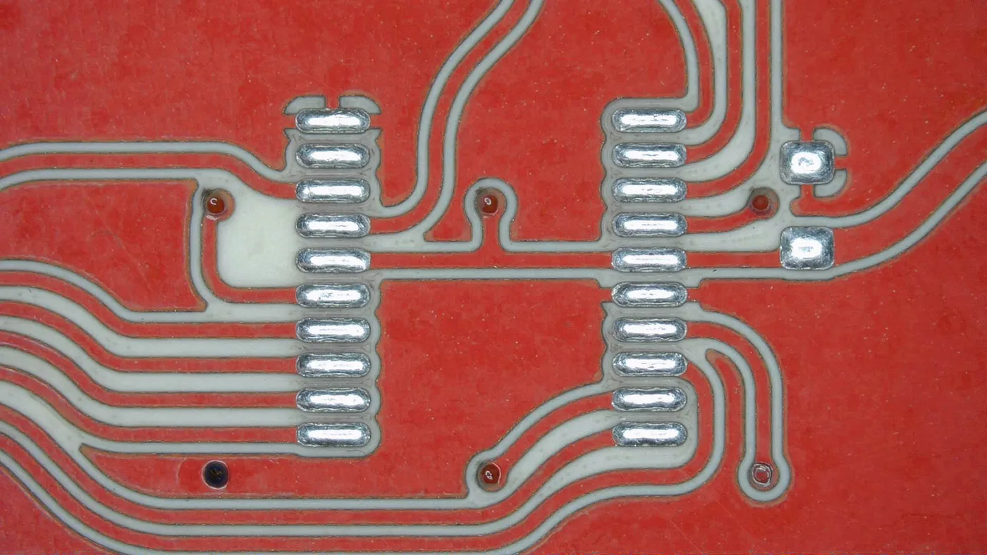 Closely spaced traces between two fine-pitch pad rows