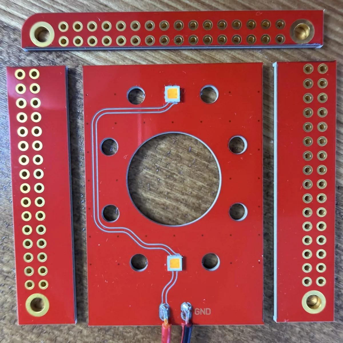 The same board snapped apart along the V-score lines into the LED board and three edge strips